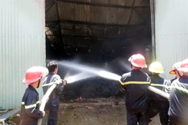 Lực lượng chữa cháy phun nước dập tắt hỏa hoạn. (Ảnh: Văn Đạt/TTXVN)