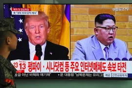 Người dân theo dõi qua truyền hình hình ảnh Tổng thống Mỹ Donald Trump (trái) và nhà lãnh đạo Triều Tiên Kim Jong-un, ngày 9/3. (Nguồn: AFP/TTXVN)