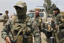 Các tay súng Lực lượng Dân chủ Syria được Mỹ hậu thuẫn tham gia chiến dịch chống IS tại tỉnh Deir Ezzor,miền đông Syria. (Ảnh: AFP/TTXVN)