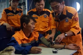 Chăm sóc y tế cho các ngư dân khi vừa cập bờ. (Ảnh: TTXVN)
