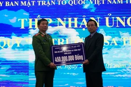 Thiếu tướng Hoàng Quốc Định, Giám đốc Cảnh sát PC&CC TP Hà Nội trao tiền ủng hộ Quỹ Vì Trường Sa thân yêu cho Ủy ban Mặt trận Tổ quốc Việt Nam thành phố Hà Nội. (Ảnh: Nguyễn Văn Cảnh/TTXVN)