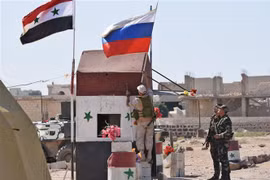 Cờ Syria (trái) và cờ Nga tại khu vực Abu Duhur, tỉnh Idlib ngày 25/9/2018. (Ảnh: AFP/TTXVN)
