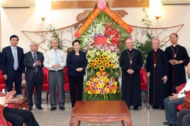 Chủ tịch Quốc hội Nguyễn Thị Kim Ngân tặng hoa chúc mừng Giám mục Giáo phận Xuân Lộc Đinh Đức Đạo. (Ảnh: Trọng Đức/TTXVN)