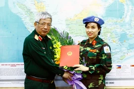 Thượng tướng Nguyễn Chí Vịnh, Ủy viên Trung ương Đảng, Ủy viên Thường vụ Quân ủy Trung ương, Thứ trưởng Bộ Quốc phòng trao Quyết định của Chủ tịch nước cho Thiếu tá Đỗ Thị Hằng Nga, Trợ lý Phòng Tham mưu - Kế hoạch thuộc Trung tâm Gìn giữ hòa bình Việt Na