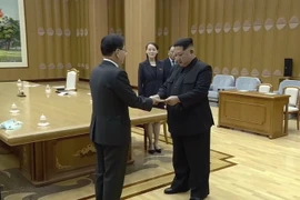 Nhà lãnh đạo Triều Tiên Kim Jong-un (phải) nhận thư của Tổng thống Hàn Quốc Moon Jae-in được ông Chung Eui-yong (trái) chuyển tới Bình Nhưỡng ngày 5/3. (Nguồn: YONHAP/TTXVN)