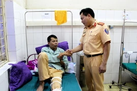 Lãnh đạo Phòng Cảnh sát giao thông Công an tỉnh Điện Biên thăm, động viên trung úy Cà Văn Mạnh tại Bệnh viện Đa khoa tỉnh Điện Biên, sáng ngày 8/6/2018. (Ảnh: Nguyễn Xuân Tiến/TTXVN)