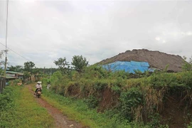 Bãi tập kết chất thải của công ty rất gần với khu dân cư nhưng không có tường rào che chắn. (Ảnh: Nguyễn Dũng/TTXVN)