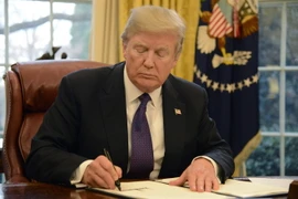 Tổng thống Mỹ Donald Trump ký một sắc lệnh tại Nhà Trắng ngày 23/1. (Nguồn: UPI-YONHAP/TTXVN)