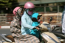 Người dân Hà Nội tham gia giao thông dưới nắng nóng. (Ảnh: Doãn Tấn/TTXVN)