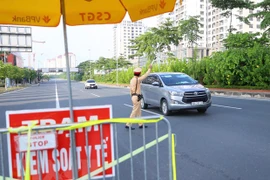Mọi người dân đi qua chốt cầu Nhật Tân đều được lực lượng chức năng kiểm tra, kiểm soát nhằm phòng, chống dịch COVID-19. (Ảnh: Hoàng Hiếu/TTXVN)