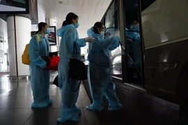 Hành khách lên ô tô về nơi cách ly tập trung. (Ảnh minh họa: Huy Hùng/TTXVN)