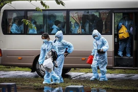 Đoàn xe chở các công dân về khu cách ly tập trung theo dõi COVID-19. (Ảnh: TTXVN)