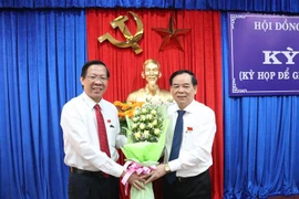 Bí thư Tỉnh ủy Bến Tre Phan Văn Mãi (bên trái) tặng hoa chúc mừng ông Trần Ngọc Tam được bầu giữ chức Chủ tịch UBND tỉnh Bến Tre, nhiệm kỳ 2016-2021. (Ảnh: Huỳnh Phúc Hậu/TTXVN)