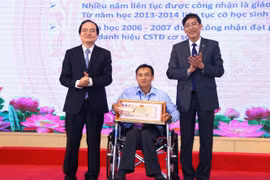 Bộ trưởng Bộ Giáo dục và Đào tạo Phùng Xuân Nhạ và Chủ tịch Công đoàn giáo dục Việt Nam Vũ Minh Đức trao Bằng khen cho thầy giáo Thái Thanh Thuận - Trường THCS Tam Bình, tỉnh Tiền Giang. (Ảnh: Hoàng Hiếu/TTXVN)