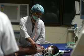 Nhân viên y tế chữa trị cho một em nhỏ tại bệnh viện Baba Raghav Das ở Gorakhpur, Ấn Độ. (Nguồn: AFP/TTXVN)