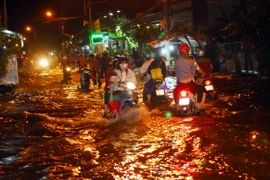 Một đoạn trên đường Lê Văn Luơng, huyện Nhà Bè bị ngập sâu trong biển nuớc. (Ảnh: Mạnh Linh/TTXVN)