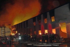 Hàng chục xe chữa cháy và lính cứu hỏa tập trung dập đám cháy. (Ảnh Tạ Toàn/TTXVN)