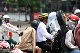 Người dân thủ đô chịu ảnh hưởng của đợt nóng kéo dài. (Ảnh: Thành Đạt/TTXVN)