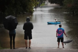 Di chuyển bằng xuồng do ngập lụt trên các tuyến phố ở Houston khi bão Harvey đổ bộ. (Nguồn: AFP/TTXVN)