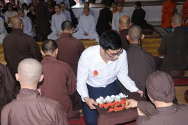 Nghi thức cài bông hồng lên áo. (Ảnh: Quang Thuận/Vietnam+)