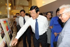 Nguyên Chủ tịch nước Trương Tấn Sang cùng phu nhân tham quan triển lãm ảnh ký sự ngoại giao tại TP.HCM. (Ảnh: Thanh Vũ/TTXVN)