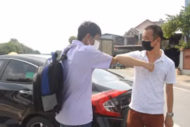 Anh Nguyễn Bình Minh (phải), người sáng lập 'Những chuyến xe yêu thương' tiếp sức cho bệnh nhân về quê mùa dịch. (Ảnh: Minh Anh/Vietnam+)