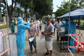 Người dân ngồi xếp hàng để được tiêm vaccine Vero Cell tại điểm tiêm Trung tâm văn hóa phường Phú Lợi, thành phố Thủ Dầu Một, tỉnh Bình Dương. (Ảnh: Chí Tưởng/TTXVN)