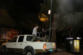 Y tế dự phòng Thành phố phun thuốc diệt muỗi và lăng quăng khu vực bên ngoài tòa nhà nơi làm việc của bệnh nhân nhiễm virus Zika. (Ảnh: Phương Vy/TTXVN)