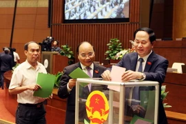 Chủ tịch nước Trần Đại Quang, Phó Thủ tướng Nguyễn Xuân Phúc và các đại biểu bỏ phiếu bầu. (Ảnh: Nguyễn Dân/TTXVN)