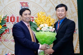 Trưởng Ban Tổ chức Trung ương Phạm Minh Chính (bên trái) tặng hoa chúc mừng tân Bí thư thứ nhất Trung ương Đoàn Lê Quốc Phong. (Ảnh: Phạm Kiên/TTXVN)