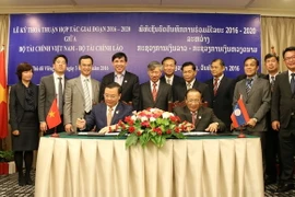 Bộ trưởng Tài chính Việt Nam Đinh Tiến Dũng và Bộ trưởng Tài chính Lào Lien Thikeo ký Thỏa thuận hợp tác giai đoạn 2016-2020. (Ảnh: Phạm Kiên/TTXVN)