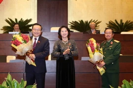 Chủ tịch Quốc hội Nguyễn Thị Kim Ngân tặng hoa chúc mừng hai Phó Chủ tịch Quốc hội mới. (Ảnh: Phương Hoa/TTXVN)