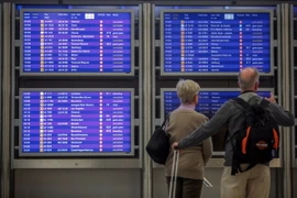 Hành khách xem bảng thông báo hủy các chuyến bay tại sân bay ở Frankfurt. (Nguồn: AFP/TTXVN)