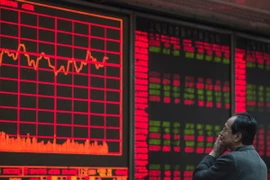 Nhà đầu tư theo dõi các chỉ số chứng khoán tại thủ đô Bắc Kinh. (Nguồn: AFP/TTXVN)