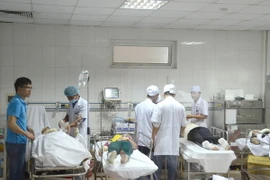 Các công nhân đang được các bác sỹ ở Bệnh viện Đa khoa 115 cấp cứu, băng bó vết thương. (Ảnh: Bích Huệ/TTXVN)