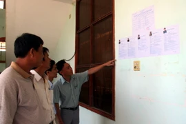 Cử tri tìm hiểu sơ bộ về ứng cử viên trước khi bắt đầu cuộc tiếp xúc. (Ảnh: Thế Lập/TTXVN)