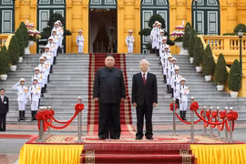 Tổng Bí thư, Chủ tịch nước Nguyễn Phú Trọng và Chủ tịch Triều Tiên Kim Jong-un trên bục danh dự, thực hiện nghi lễ chào cờ. (Ảnh: Trí Dũng/TTXVN)