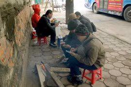 Người dân trên phố Trần Khánh Dư đốt củi để sưởi ấm. (Ảnh: Quang Quyết-TTXVN)