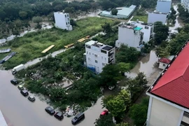 Một khu dân cư trên đường Nguyễn Lương Bằng, quận 7, TP Hồ Chí Minh, bị bao quanh bởi “biển nước” do mưa lớn và triều cường. (Ảnh: Thu Hương/TTXVN)