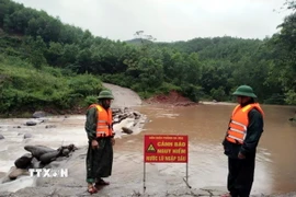 Lực lượng Đồn Biên phòng Ra Mai, huyện Minh Hóa, chốt chặn không cho người dân qua các ngầm tràn khi nước lũ dâng cao. (Ảnh: TTXVN phát)