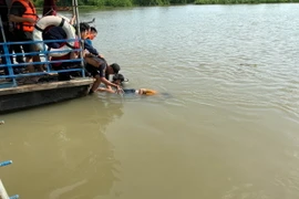 Lực lượng cứu hộ cứu nạn đã tìm thấy 1 thi đầu tiên trong vụ 3 bé gái mất tích trên sông Sài Gòn. (Ảnh: Dương Chí Tưởng/TTXVN)