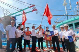 Bộ Tư lệnh Vùng 4 Hải quân tặng cờ Tổ quốc, áo phao và quà cho ngư dân tại cảng cá Mỹ Tân, xã Thanh Hải, huyện Ninh Hải, tỉnh Ninh Thuận. (Ảnh: Nguyễn Thành/TTXVN)