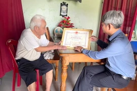 Ông Nguyễn Anh Trung (trái) xã Triệu Hòa có 2 Bằng khen của Mặt trận B5 và Huân chương kháng chiến chống Mỹ đến nay chưa được cấp lại. (Ảnh: Thanh Thủy/TTXVN)