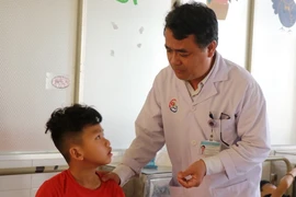 Bác sỹ Chuyên khoa II Phạm Đình Thành, Phó giám đốc Trung tâm Chấn thương chỉnh hình-Bỏng, Bệnh viện Đa khoa tỉnh Khánh Hòa thăm bệnh nhân bị chấn thương các ngón tay do pháo hoa. (Ảnh: Phan Sáu/TTXVN)