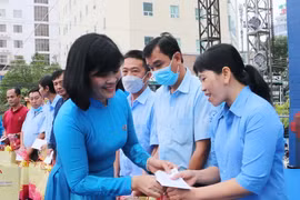Bà Đỗ Thị Hồng Vân, Ủy viên Đoàn Chủ tịch, Trưởng ban Nữ công Tổng Liên đoàn Lao động Việt Nam trao quà Tết cho đoàn viên, người lao động có hoàn cảnh khó khăn dịp Tết Nguyên đán 2023. (Ảnh: Công Mạo/TTXVN)