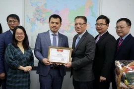 Đại sứ Đặng Minh Khôi (thứ 3 từ phải qua) tặng bằng khen cho ông Nguyễn Anh Phương, Trưởng văn phòng đại diện Tập đoàn dầu khí Việt Nam tại LB Nga. (Ảnh: Quang Vinh/TTXVN)