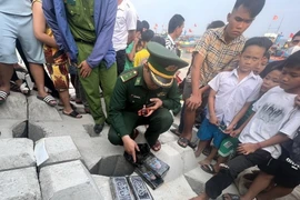 Bộ đội Biên phòng Bình Hải tiếp nhận, thu giữ các gói cocaine. (Ảnh: TTXVN phát)