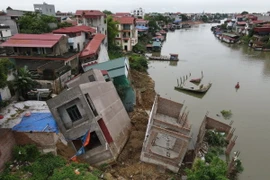 Hiện trường vụ sạt lở khiến nhiều ngôi nhà bị rạn nứt, nghiêng, bị hư hại nghiêm trọng. (Ảnh: Thanh Thương/TTXVN)