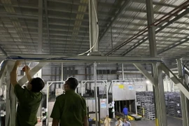 Lực lượng chức năng khám nghiệm hiện trường nơi chị Võ Thị Ngọc A., công nhân Công ty Leoch Super Power-Khu Công nghiệp Becamex Bình Phước tử vong chiều tối 25/5. (Ảnh: TTXVN phát)