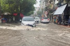 Khu vực Vĩnh Hưng, quận Hoàng Mai, các phương tiện tham gia giao thông gặp khó khăn khi mưa lớn và sấm sét liên tục. (Ảnh: Phạm Tuấn Anh/TTXVN)